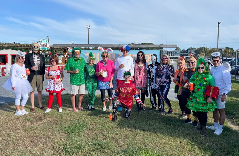 Costumed friends and family enjoy a drink before starting the rally. Standing are (l-r) Jennifer Gemmell, Todd Conway, Jeanine Yzaguirre, Bee Linzey, Susannah Baden, Liz Zehner, Jack Edwards, Coryn Cannon, Mike Sewell, Molly Sewell, Diann Rassman, Larry Wilde, Amy Linzey and Chris Linzey. Kneeling in the front is Ava Cannon. SUBMITTED PHOTO